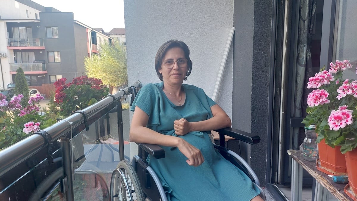 Mariana, pe balconul casei, în scaunul cu rotile, alături de florile ei